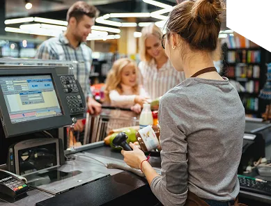 Cashier serving a family at a retail point of sale terminal